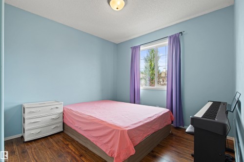 Wood-finish flooring, light blue wall paint, and a white framed window - 9118 Scott Crescent Nw, Edmonton, AB - Indoor Photo Showing Bedroom