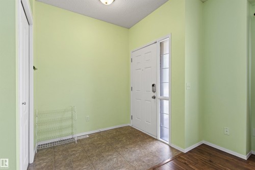Entryway featuring a white paneled door with a sidelight, tile flooring, and a flush mount ceiling light - 9118 Scott Crescent Nw, Edmonton, AB - Indoor Photo Showing Other Room
