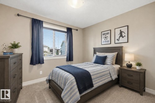 Plush carpet flooring, neutral paint palette, and a window with blinds and drapes - 49 Navajo Ln, Fort Saskatchewan, AB - Indoor Photo Showing Bedroom
