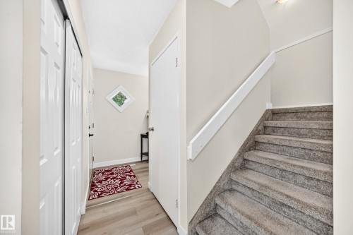 Neutral-toned walls complement wood-finish flooring in the entry - #22 3812 20 Av Nw, Edmonton, AB - Indoor Photo Showing Other Room