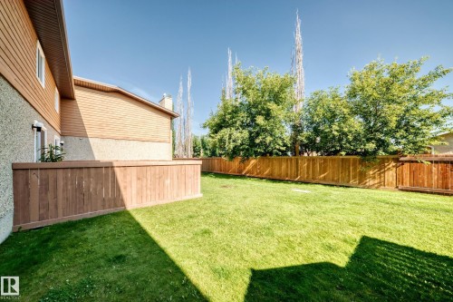 Expansive yard featuring a manicured lawn and perimeter wood fencing - #22 3812 20 Av Nw, Edmonton, AB - Outdoor With Backyard