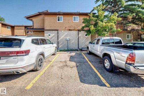 Paved parking area featuring striped parking spaces - #22 3812 20 Av Nw, Edmonton, AB - Outdoor