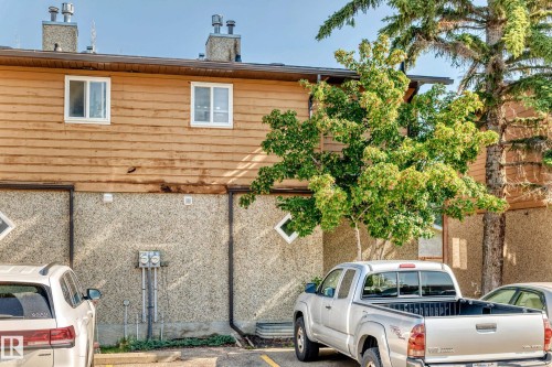 Two-story exterior featuring horizontal wood siding, a textured aggregate lower facade, and white-framed windows - #22 3812 20 Av Nw, Edmonton, AB - Outdoor With Exterior