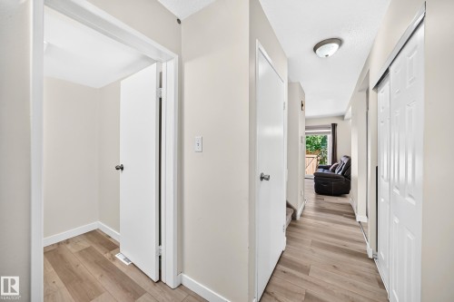 Hallway featuring wood-finish flooring, overhead lighting, and white walls - #22 3812 20 Av Nw, Edmonton, AB - Indoor Photo Showing Other Room