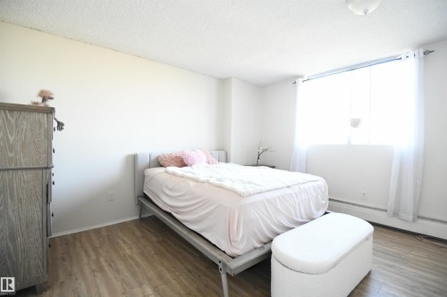 The master bedroom easily supports king sized furniture, has a great window for light and view, as well as a full wall of floor to ceiling closets - #1305 13910 Stony Plain Rd Nw, Edmonton, AB - Indoor Photo Showing Bedroom