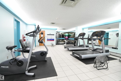 The fitness room is well equipped, and has lots of light and space for anyone who wants to work out.  Or take a quiet walk through the stunning tree-lined streets of Glenora, just waiting for you - #1305 13910 Stony Plain Rd Nw, Edmonton, AB - Indoor Photo Showing Gym Room