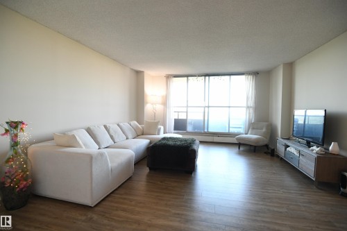 Being a concrete high rise, the suite is quiet and comfortable.  Large windows let in outstanding natural light, and the open layout is inviting - #1305 13910 Stony Plain Rd Nw, Edmonton, AB - Indoor Photo Showing Living Room