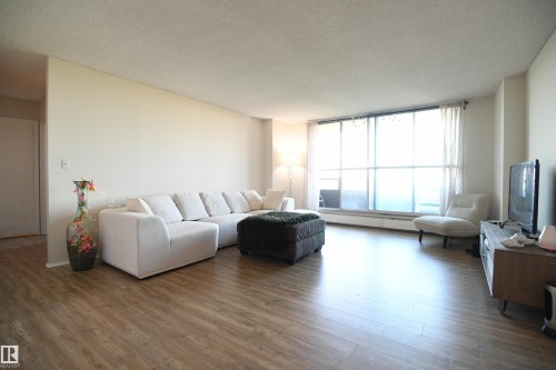 Being a concrete high rise, the suite is quiet and comfortable.  Large windows let in outstanding natural light, and the open layout is inviting - #1305 13910 Stony Plain Rd Nw, Edmonton, AB - Indoor Photo Showing Living Room