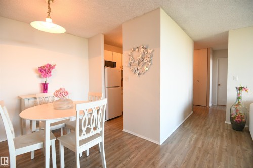 Perfect for a table large enough to entertain a few friends, the dining room is open to the living space, allowing you to enjoy the light, and view, from the wall of windows - #1305 13910 Stony Plain Rd Nw, Edmonton, AB - Indoor Photo Showing Dining Room