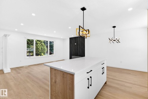 Kitchen island featuring a white countertop and wood-finish paneling - 5 Peace River Drive, Devon, AB - Indoor