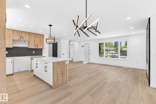 Open concept living area featuring wood-finish flooring, recessed lighting, and a contemporary linear chandelier - 5 Peace River Drive, Devon, AB - Indoor Photo Showing Kitchen