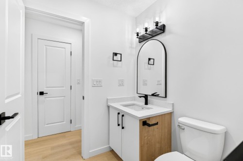 White vanity with wood-finish paneling and integrated sink - 5 Peace River Drive, Devon, AB - Indoor Photo Showing Bathroom