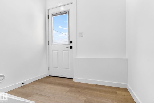 White paneled door with a half-lite window and matte black hardware - 5 Peace River Drive, Devon, AB - Indoor Photo Showing Other Room