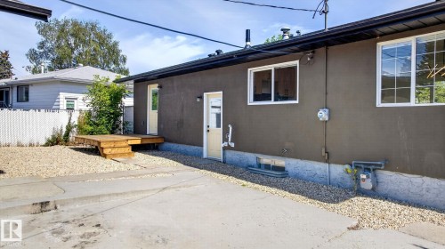 Exterior featuring a wooden deck, gravel landscaping, and light-colored doors - 5 Peace River Drive, Devon, AB - Outdoor With Exterior