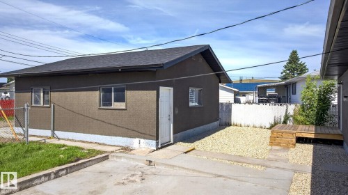 Detached garage with dark shingle roof, stucco exterior, and white entry door - 5 Peace River Drive, Devon, AB - Outdoor With Exterior