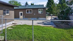 Manicured lawn with chain-link fencing and concrete patio area - 