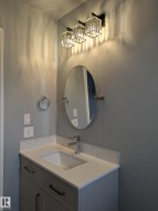 Vanity featuring a rectangular undermount sink, a chrome single-handle faucet, and white countertop with matching backsplash - 