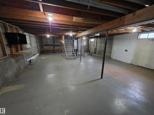 Expansive lower level with painted concrete flooring, exposed wood beam ceiling, and concrete foundation walls - 1907 145A Avenue Nw, Edmonton, AB - Indoor Photo Showing Basement