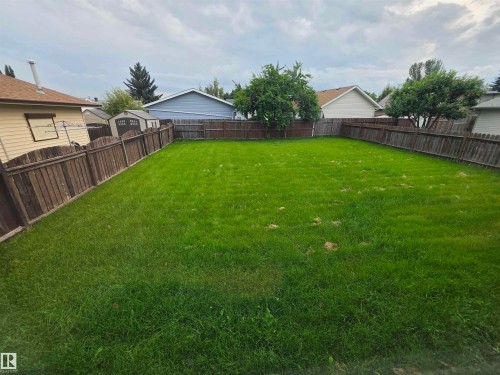 Expansive grass yard with wood fencing enclosing the perimeter - 1907 145A Avenue Nw, Edmonton, AB - Outdoor With Backyard