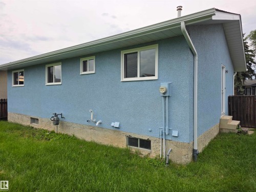 Blue stucco exterior with white-framed windows, white soffits, and white gutters - 1907 145A Avenue Nw, Edmonton, AB - Outdoor With Exterior