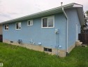 Blue stucco exterior with white-framed windows, white soffits, and white gutters - 1907 145A Avenue Nw, Edmonton, AB  - Outdoor With Exterior 