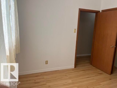Room featuring wood-finish flooring, white baseboards, and neutral wall paint - 5213 50 Avenue, Vegreville, AB - Indoor Photo Showing Other Room