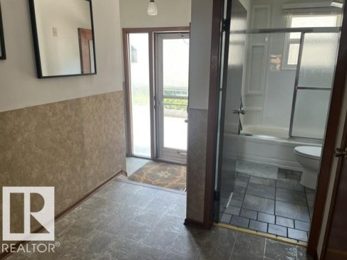Entryway featuring neutral-toned wainscoting and durable tile flooring - 5213 50 Avenue, Vegreville, AB - Indoor