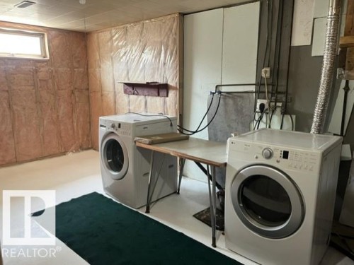 Utility area featuring a window, exposed wall insulation, and a concrete floor - 5213 50 Avenue, Vegreville, AB - Indoor Photo Showing Laundry Room
