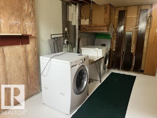 Laundry area featuring white appliances, a light-colored floor, and exposed wall framing - 5213 50 Avenue, Vegreville, AB - Indoor Photo Showing Laundry Room