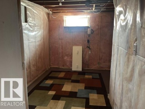 Unfinished basement area featuring exposed ceiling joists, an egress window, and visible insulation - 5213 50 Avenue, Vegreville, AB - Indoor Photo Showing Basement