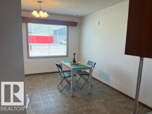 Dining area featuring a large window with horizontal blinds and a decorative valance - 5213 50 Avenue, Vegreville, AB - Indoor