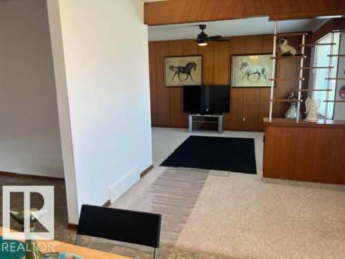 Living area with wood-paneled walls and a ceiling fan - 5213 50 Avenue, Vegreville, AB - Indoor Photo Showing Other Room