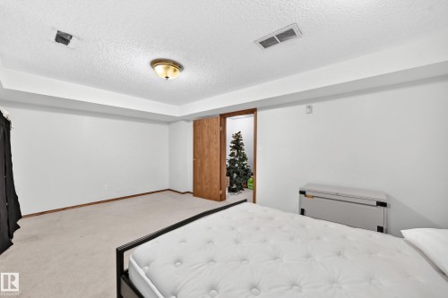 Spacious bedroom with recessed ceiling detail and brass-finish flush-mount ceiling fixture - 6 Atkinson Place, St. Albert, AB - Indoor Photo Showing Bedroom
