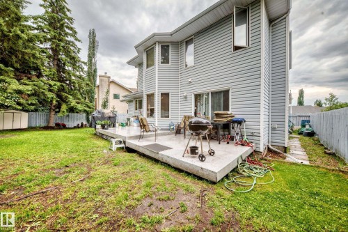 Expansive rear exterior featuring light-colored siding, a concrete patio, and mature perimeter trees - 6 Atkinson Place, St. Albert, AB - Outdoor With Deck Patio Veranda