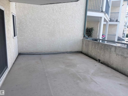 Balcony featuring a concrete surface, stucco exterior wall, and metal railings - #208 6710 158 Av Nw, Edmonton, AB - Outdoor With Balcony