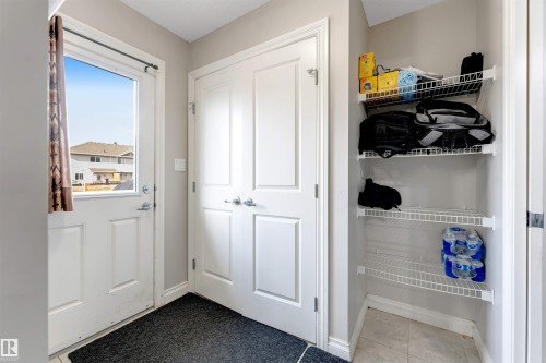 Entryway featuring a white door with a window, tile flooring, and a built-in shelving unit - 3106 15 Avenue Nw, Edmonton, AB - Indoor Photo Showing Other Room