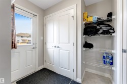 Entryway featuring a white door with a window, tile flooring, and a built-in shelving unit - 