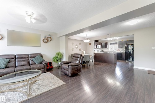 Spacious living area with wood-finish flooring, recessed lighting, and a ceiling fan - 3106 15 Avenue Nw, Edmonton, AB - Indoor Photo Showing Living Room