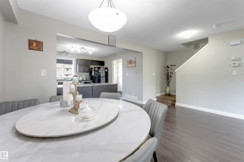 Recessed kitchen with dark wood-finish cabinetry, solid surface countertops, and stainless steel appliances - 3106 15 Avenue Nw, Edmonton, AB - Indoor Photo Showing Dining Room