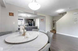 Recessed kitchen with dark wood-finish cabinetry, solid surface countertops, and stainless steel appliances - 