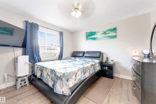 Wood-finish flooring, light-toned walls, and a window with blinds and drapes - 3106 15 Avenue Nw, Edmonton, AB - Indoor Photo Showing Bedroom