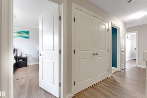 Wood-finish flooring throughout, white panel doors, and flush-mount lighting fixtures - 3106 15 Avenue Nw, Edmonton, AB - Indoor Photo Showing Other Room