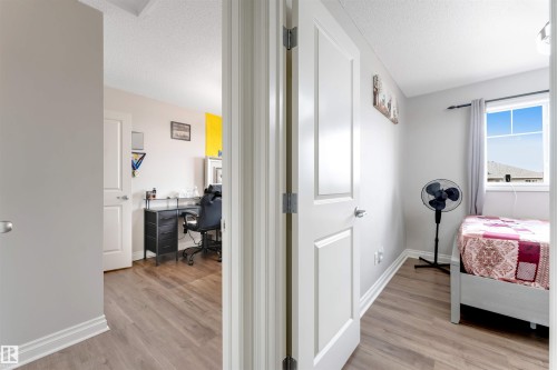 Wood-finish flooring throughout, white interior doors, and neutral wall tones - 3106 15 Avenue Nw, Edmonton, AB - Indoor Photo Showing Bedroom