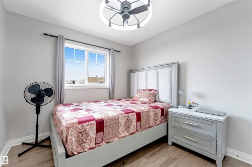 Wood-finish flooring, white walls, and a window with light gray drapes - 3106 15 Avenue Nw, Edmonton, AB - Indoor Photo Showing Bedroom