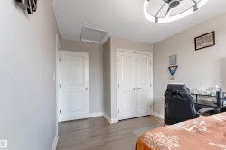 Wood-finish flooring, light grey wall paint, white trim, and a contemporary ceiling fixture - 