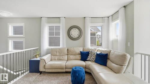 Bright, multi-windowed living space with abundant natural light and custom window treatments - 63 Rosemount Boulevard, Beaumont, AB - Indoor Photo Showing Living Room