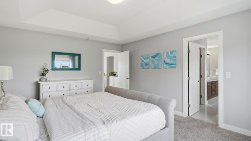 Serene primary bedroom showcasing soft gray walls, recessed ceiling lighting, and carpet flooring - 63 Rosemount Boulevard, Beaumont, AB - Indoor Photo Showing Bedroom