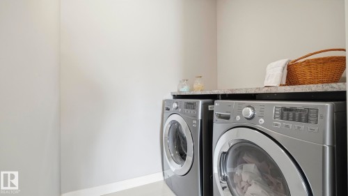 Front-load washing machine and dryer with a countertop - 63 Rosemount Boulevard, Beaumont, AB - Indoor Photo Showing Laundry Room