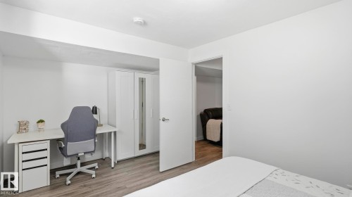 Bright bedroom with wood-finish flooring, abundant natural light, and direct access to an ensuite bathroom - 63 Rosemount Boulevard, Beaumont, AB - Indoor Photo Showing Bedroom