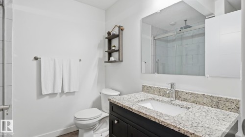 Modern bathroom featuring a floating vanity with dual-sink configuration, polished stone countertop, and chrome faucetry - 63 Rosemount Boulevard, Beaumont, AB - Indoor Photo Showing Bathroom